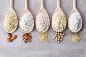 A row of spoons with different types of grains in them.